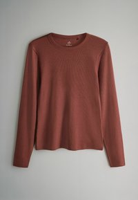 Majica z dolgimi rokavi v rjavi barvi, rebraste teksture, z okroglim izrezom, ob straneh razporki na spodnjem robu za sproščen prileganje. Material je mehak in lahek.