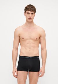Μαύρα βαμβακερά μποξάκια με εφαρμοστό σχέδιο και φαρδιά ελαστική ζώνη που φέρει το λογότυπο "Calvin Klein" σε λευκό χρώμα.