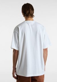 Bílý bavlněný tričko s krátkým rukávem a kulatým výstřihem, se uvolněným střihem a hladkou texturou, zobrazené ze zadní strany.