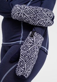 Strikkede vanter har et marineblåt og lysgråt geometrisk mønster. Designet inkluderer en blød tekstur og et lille mærke med teksten 'DOVRE.'