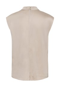 Blouse beige sans manches avec col montant et fermeture éclair au dos, tissu lisse, ourlet légèrement arrondi, vue de dos.