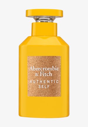 Gult rektangulært parfume-flakon med en klar rund hætte og en etiket med korktekstur, der lyder "Abercrombie & Fitch Authentic Self".