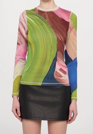 Langärmeliges Oberteil mit abstrakten Pinselstrichmustern in Grün, Pink, Braun und Blau, kombiniert mit einem kurzen schwarzen Lederrock.