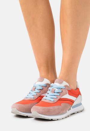 Sneakers featuring a mix of orange fabric, pink suede, and white accents, with light blue laces and a textured rubber sole.