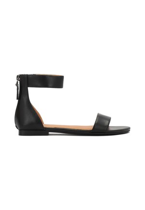 Sandalia de cuero negro con una correa en el tobillo, suela plana y diseño minimalista. Presenta una cremallera lateral y una amplia correa en la parte delantera.