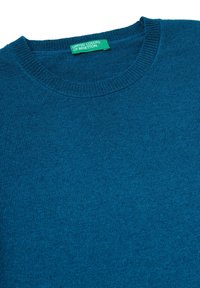 Modrý pletený svetr s kulatým výstřihem. Vybaven texturovanou látkou a štítkem se nápisem "United Colors of Benetton" v zelené barvě.