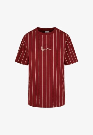 Czerwona koszulka z krótkim rękawem, z pionowymi kremowymi paskami i centralnym haftowanym logo w białym kolorze. Okrągły dekolt, luźny fason, materiał bawełniany.