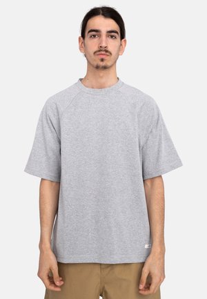 Lys grå kortærmet t-shirt lavet af blødt bomuld. Har en rund halsudskæring og raglanærmer. Lige pasform med et lille logo ved sømmen.
