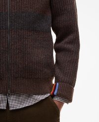 Pull de sweat marron à fermeture éclair avec un motif texturé en côtes, présentant une bande sombre contrastante et un accent multicolore au niveau des poignets.