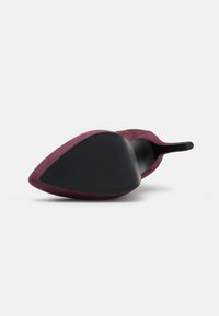 Bordeaux lodičky na vysokém podpatku s špičatou špičkou, velurové svršky a černá gumová podrážka s texturovaným vzorem. Elegatní design s minimalistickými detaily.