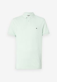 Polo vert clair à manches courtes avec deux boutons et petit logo Tommy Hilfiger sur la poitrine gauche.