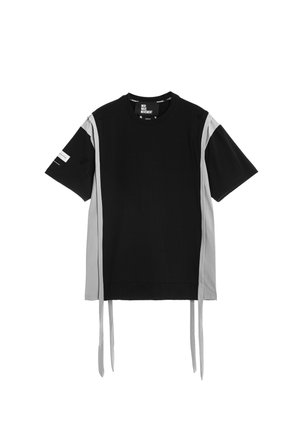 Camiseta negra de manga corta con paneles laterales grises y largas tiras de tela gris colgando del dobladillo.