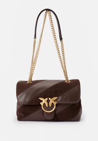 Brūna ādas un zamšādas rokassoma ar diagonālas svītras dizainu, zelta ķēdes siksniņu un dekoratīvu zelta putna simbolu.