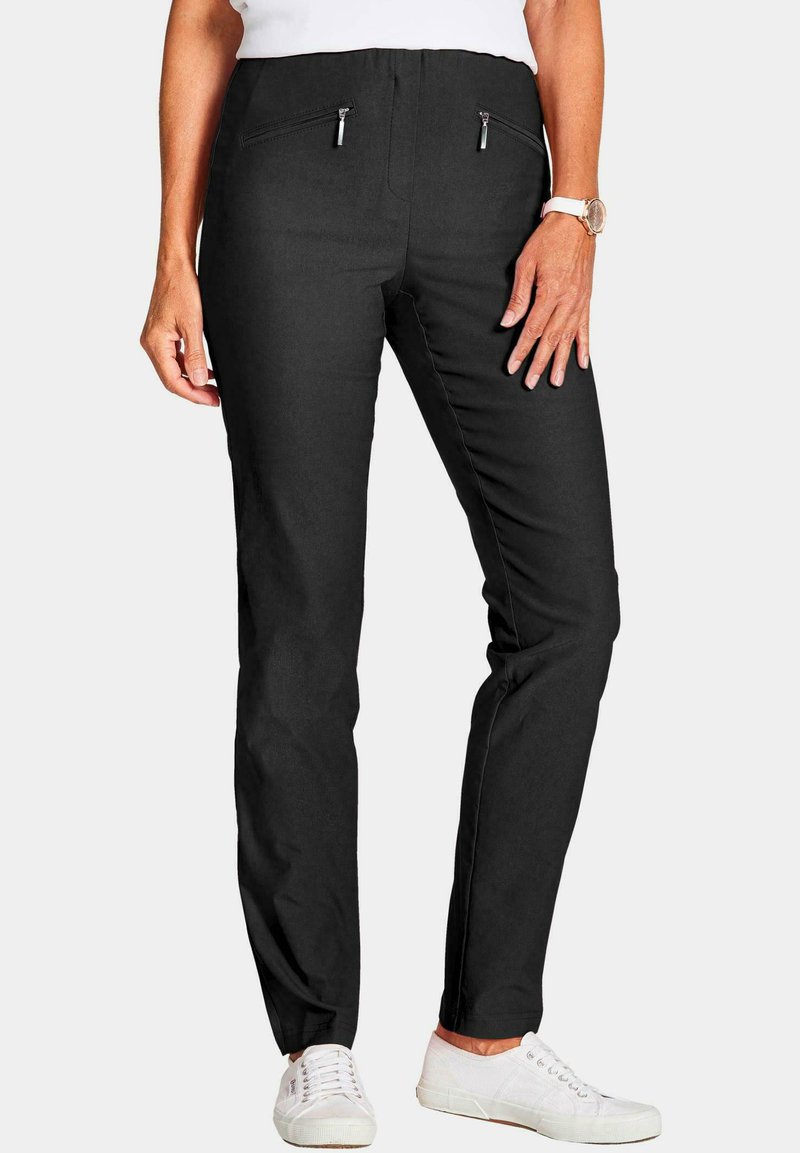 Zwarte broek met een tailored fit, voorzien van twee voorzakken met rits en een zachte katoenmix. Draag met witte sneakers.