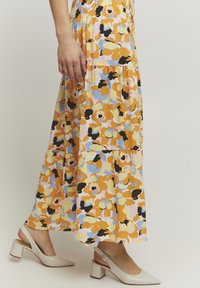 Bloemenlange rok met oranje, roze en blauwe patronen op een lichte achtergrond, gemaakt van lichtgewicht stof met een elastische tailleband.