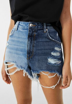 Pantalones cortos de mezclilla con un degradado de claro a oscuro, detalles desgastados, dobladillos deshilachados y diseño de cinco bolsillos con cierre de botón en la cintura.