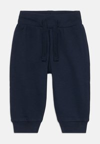 M�ørkeblå joggebukser laget av myk stoff, med en ribbet livlinning med snor, avsmalnende ermer og uten synlige mønstre eller tilbehør.