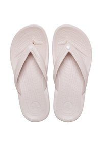Des tongs rose pâle avec un semelle texturée, des fines lanières et un détail de logo circulaire. Fabriquées en caoutchouc flexible.