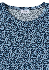 Chemise bleu marine à col rond avec motif de feuilles bleu clair et étiquette de marque "CECIL" à l'intérieur du col.