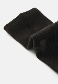 Black knitted sock with a ribbed texture, featuring a smooth cuff and soft fabric, partially rolled over to reveal the interior lining.