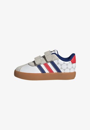 Zapatilla infantil blanca y gris con rayas azules y rojas, dos tiras beige de velcro, suela de goma y forro interior azul.
