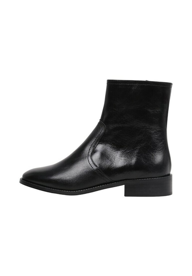 Botas de tobillo de cuero negro con un diseño elegante, punta afilada y tacón bajo apilado. Textura suave y detalle de costura sutil.