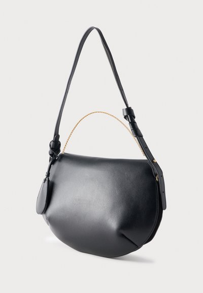 Μαύρη δερμάτινη τσάντα ώμου με καμπυλωτό σχήμα, ρυθμιζόμενο λουρί με πόρπη, μικρή χρυσή αλυσίδα χειρολαβής και προσαρτημένη οβάλ δερμάτινη ετικέτα.