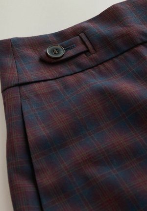 Plaid fabric in dark red and navy, featuring a pleated design and a single black button on the waistband. Smooth texture and tailored fit.