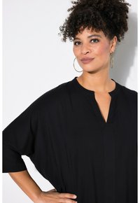 Blusa nera morbida con scollatura a V e maniche corte, caratterizzata da pieghe sottili e una texture di tessuto leggera e liscia.