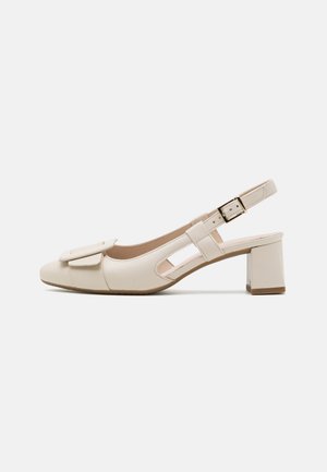 Beżowe buty na obcasie typu slingback ze kwadratowym noskiem, blokowym obcasem i dekoracyjną kokardą z przodu. Posiadają wycięcia po bokach oraz regulowany pasek.