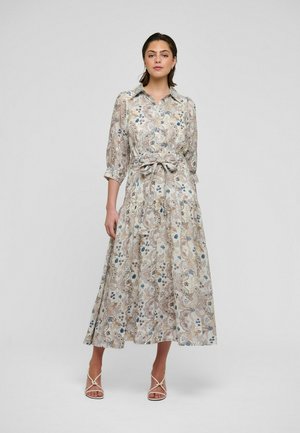 Õhukese beežika kangaga lillemustriga maksikleit, millel on triiksärgikaelus, kolmeveerandvarrukad ja vöökohal pael, siniste ja roheliste aktsentidega.