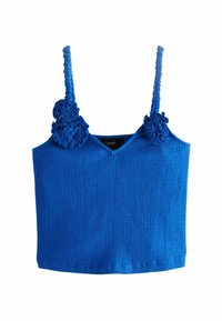 Top sin mangas de un vibrante color azul con textura acanalada, que presenta flores decorativas de tela en los tirantes y un diseño de escote en V.