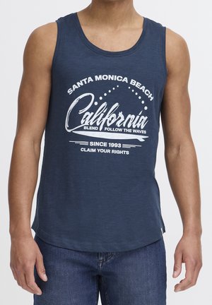 Marineblå tanktop lavet af blødt materiale, der har et hvidt grafisk print med tekst og bølgemønstre. Rundet nederste kant, afslappet pasform.