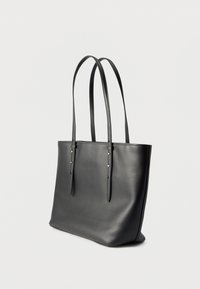 Μαύρη δερμάτινη τσάντα ώμου με δύο μακριές ρυθμιζόμενες λουριά ώμου και χρυσές αγκράφες σε απλό ανοιχτό φόντο.