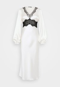 Balta satīna kleita ar garām pūderētām piedurknēm un melnām mežģīnēm pie kakla izgriezuma un krūškurvja. Gluda tekstūra, pieguļošs siluets.