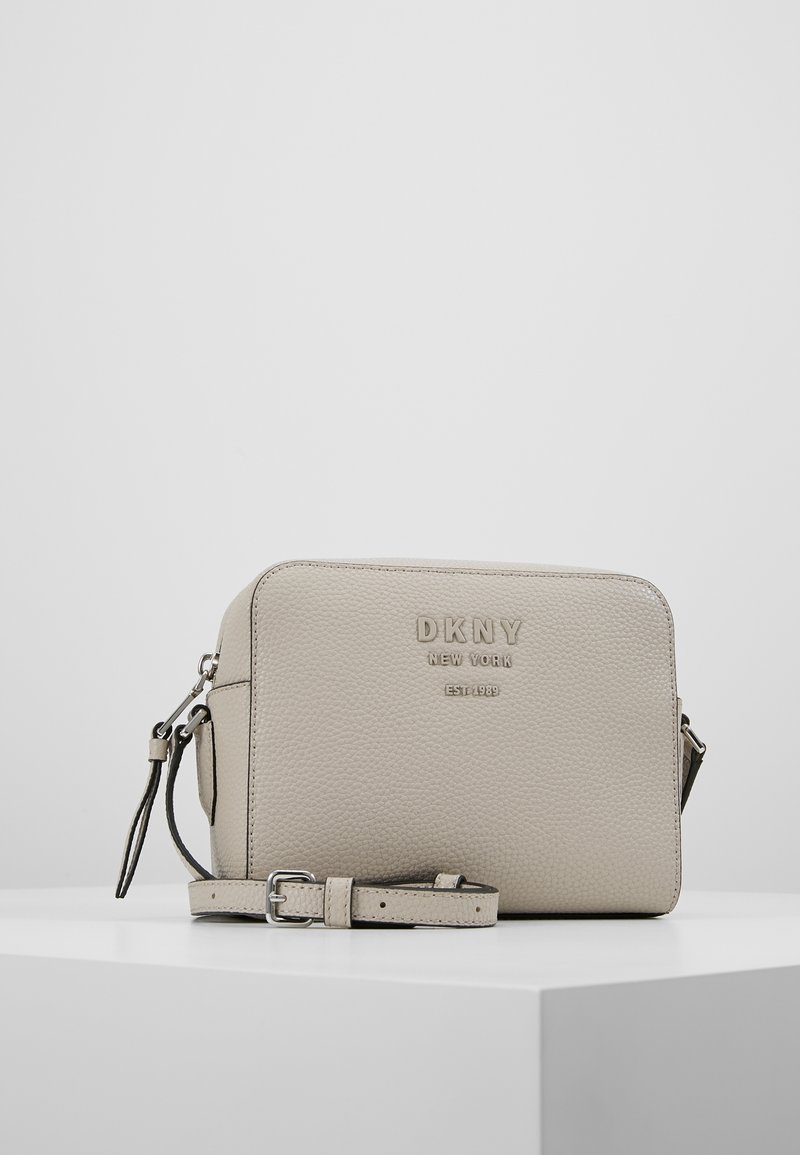 Borsa a tracolla in pelle grigia chiaro con texture e tracolla regolabile. Presenta logo in rilievo, chiusura con zip e forma rettangolare.