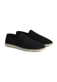 Zwarte instap schoenen van zachte stof, met een ronde neus, een gestructureerde bovenkant en een contrasterende crèmekleurige gevlochten zool.