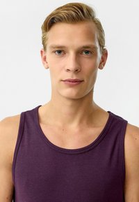 Paars mouwloos tanktop met een ronde hals, gemaakt van gladde stof, met een aansluitend ontwerp en minimale naden. Eenvoudig zonder patronen.