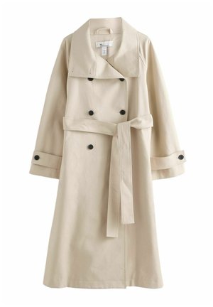 Beige trench coat vyrobený z hladkého materiálu, s širokým límcem, dvouřadým zapínáním na černé knoflíky a s opaskem uvázaným v pase.