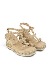 Sandales compensées beiges avec des lanières transparentes, semelle intérieure texturée et détails tissés. Présente un design en jute tressé sur la semelle.