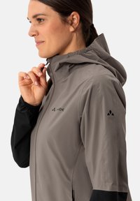 Giacca leggera con cappuccio da donna grigia con maniche nere. Caratterizzata da una zip completa, polsini elasticizzati e accenti del logo sul petto e sulla manica.