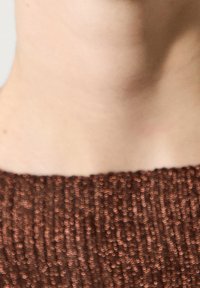 Ruskea, teksturoidulla pinnalla varustettu neulepaita, jossa on röyhelömuotoilu ja pyöreä pääntie. Kankaassa on läpi kulkeva metallinen hohde.