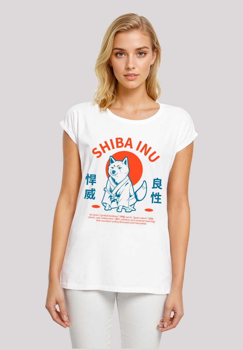 White short-sleeve t-shirt featuring a graphic of a Shiba Inu dog, with orange and blue text elements and an illustrated design.