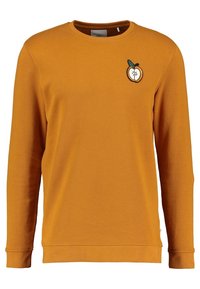 Sudadera mostaza de manga larga, con puños y dobladillo acanalados. Presenta un pequeño logotipo de durazno con una hoja bordada en el pecho.
