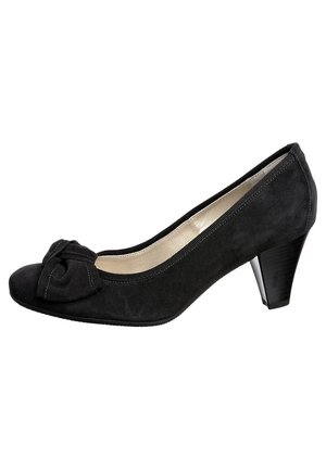 Sort ruskind højhælet sko med rundet tå, dekorativ sløjfe foran og tekstureret hæl med let glans.