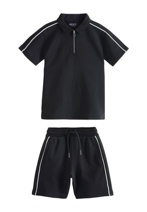 Mustast lühikeste varrukatega polosärk, millel on ees lukk, ning sobivad mustad lühikesed püksid elastse vöökohaga, mõlemal valge küljeriba.