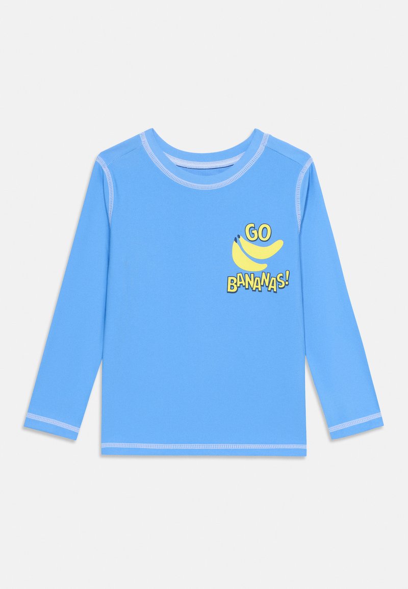 Chemise bleu clair à manches longues avec coutures blanches et un graphique jaune de deux bananes avec le texte « GO BANANAS! » sur la poitrine.