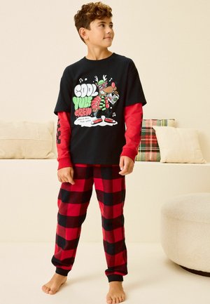 Schwarzes T-Shirt mit kurzen Ärmeln und Grafikdesign eines Rentiers, darunter rote lange Ärmel, rot-schwarz karierten Schlafanzughosen.