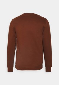 Sudadera marrón con cuello redondo, mangas largas y puños acanalados. Textura de tela suave y diseño minimalista sin logotipos visibles.