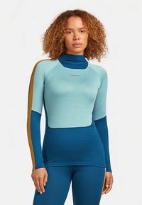 Athletische top met lange mouwen, met een lichtblauw bovenstuk, donkerblauwe mouwen en gouden accenten, gemaakt van een zachte stretchstof.